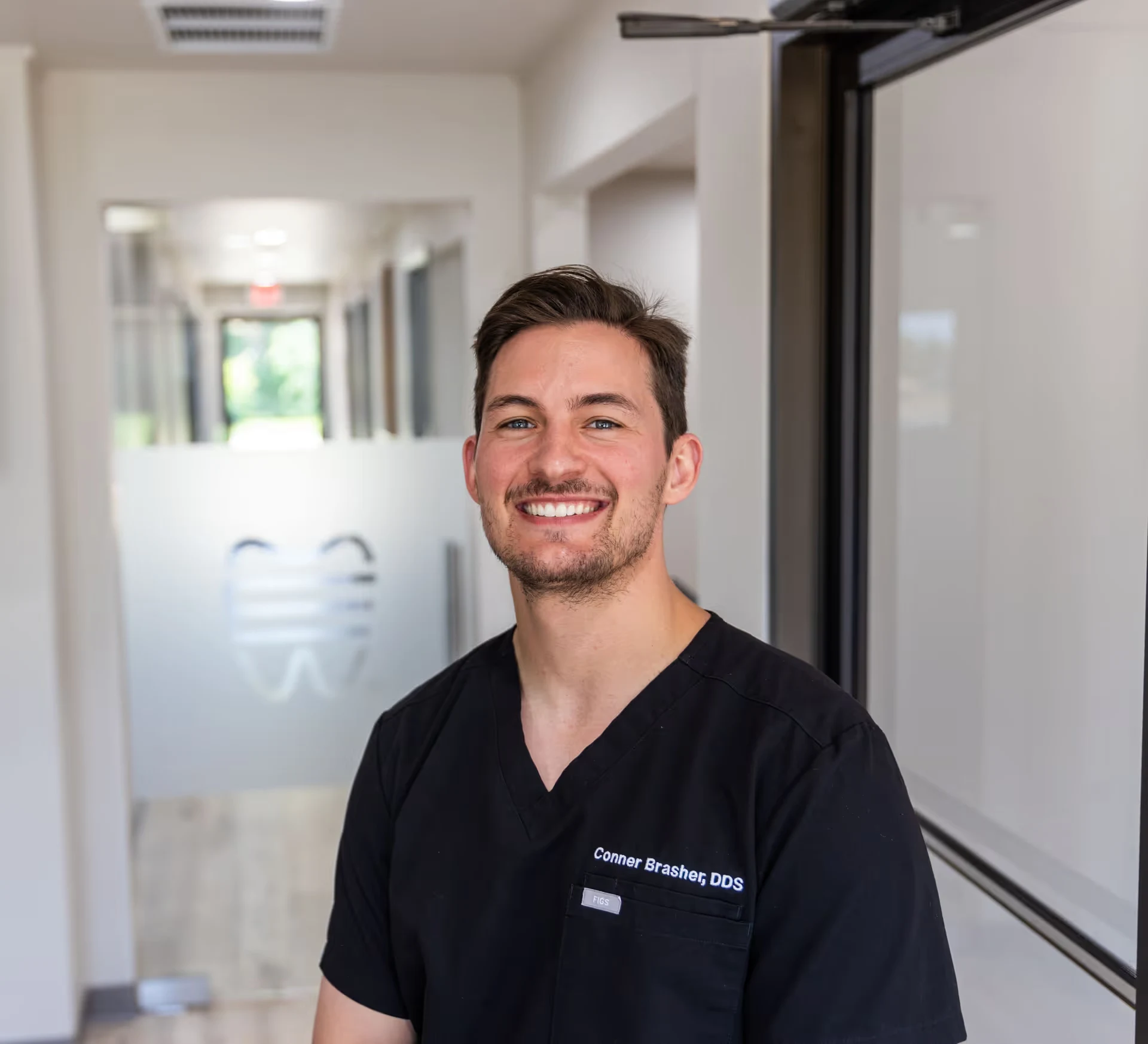 Dr. Conner Brasher, DDS, in scrubs in the Epic Dental office hallway