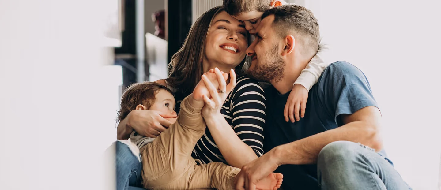 Parents and young children affectionate together indoors